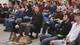 Reveille, her handler Ian Moss, a construction science major, and an audience listen to the event's keynote address..